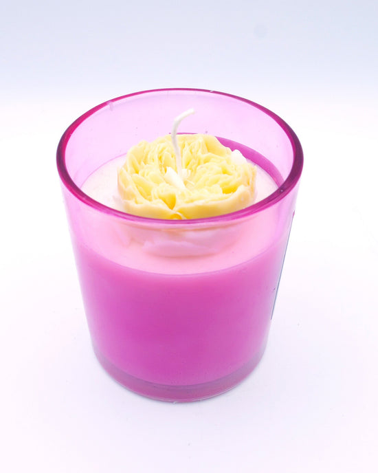 Vela con flor en vaso de color