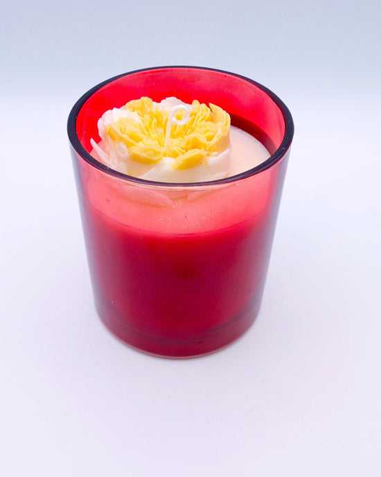 Vela con flor en vaso de color